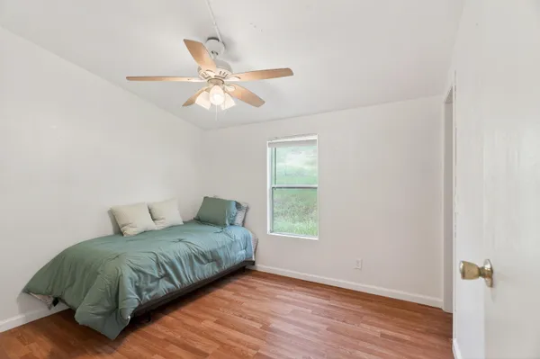a bathroom with a toilet a sink a mirror and a window