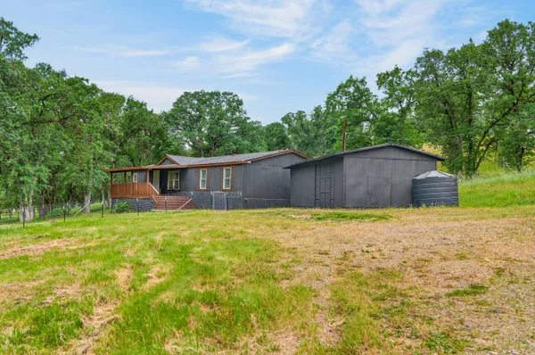 a front view of house with yard and trees in the background