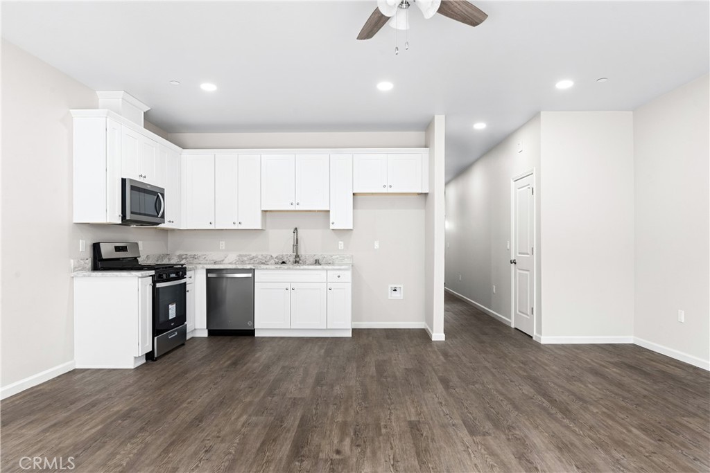 5583 Linrich Lane Paradise, CA 95969 - Photo 12 of 33 a kitchen with granite countertop a refrigerator oven a sink dishwasher and white cabinets with wooden floor