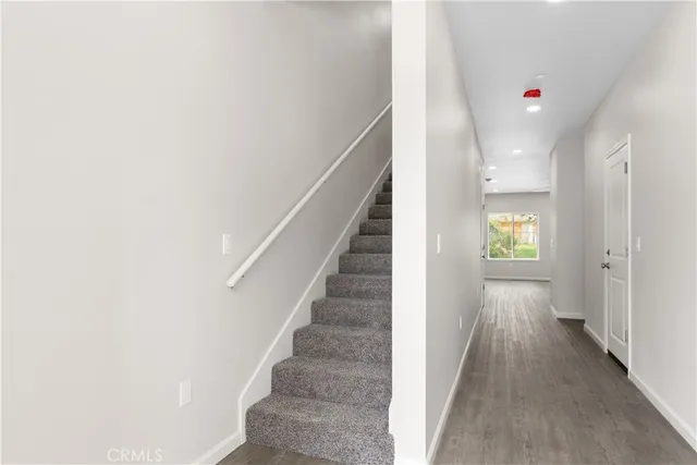 a view of a hallway with wooden floor and entryway