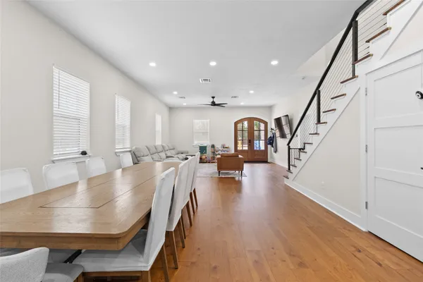 a kitchen with stainless steel appliances granite countertop a sink a stove a refrigerator and island with wooden floor