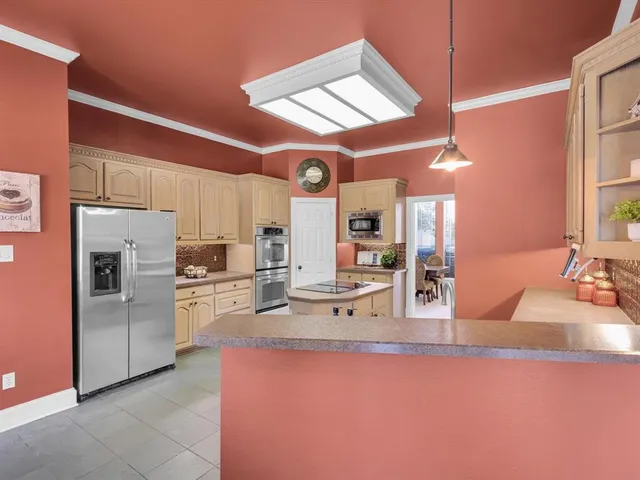 a kitchen with stainless steel appliances kitchen island granite countertop a sink refrigerator and cabinets