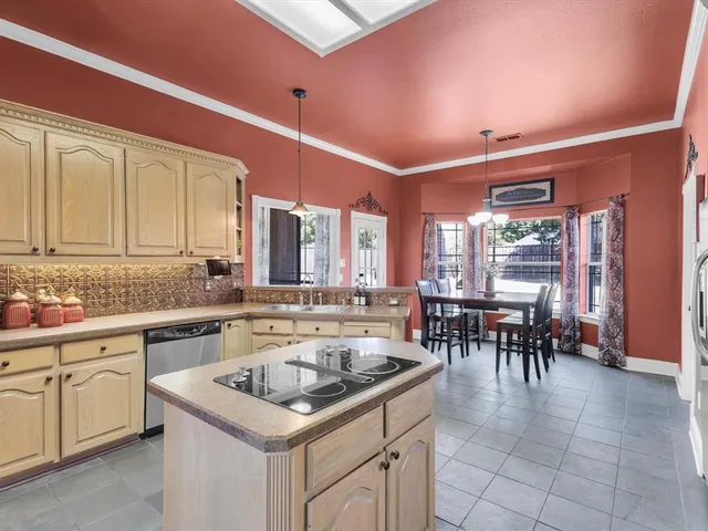 a kitchen with a stove a sink a dining table and chairs