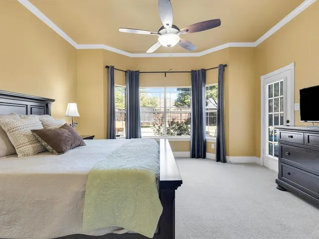 a bed room with a bed television and a large window