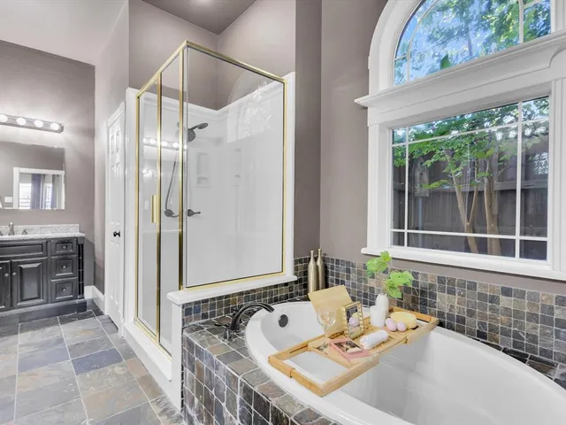 a bathroom with a tub sink and mirror