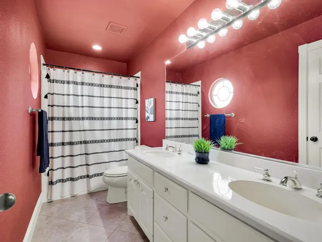 a bathroom with a double vanity sink toilet and a mirror