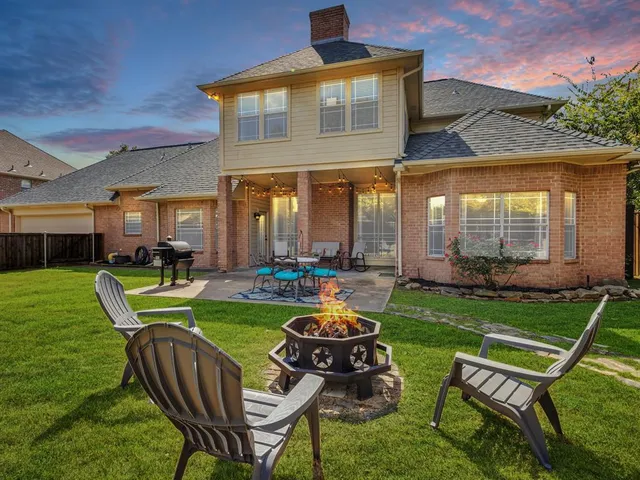 a view of a chair and table in back yard of a house
