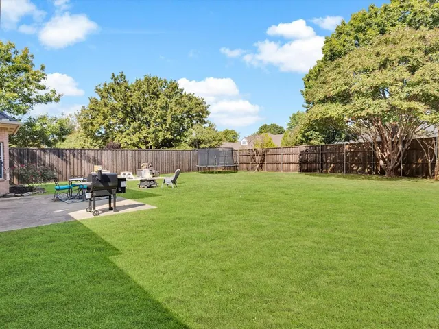 a view of a backyard with a garden and outdoor seating