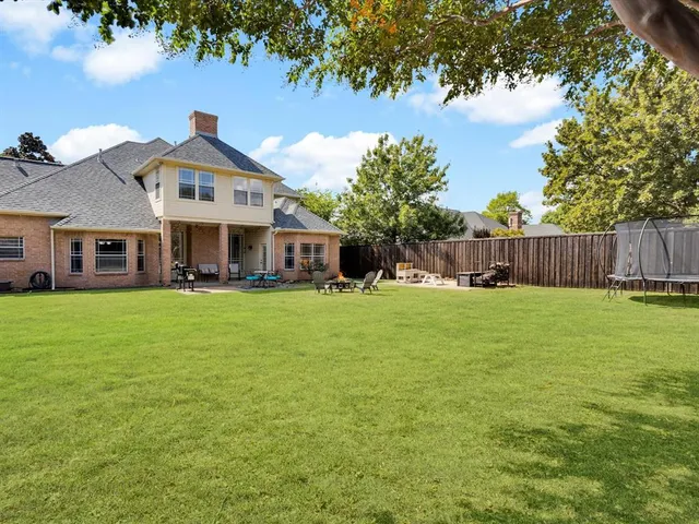 a front view of a house with a garden and trees