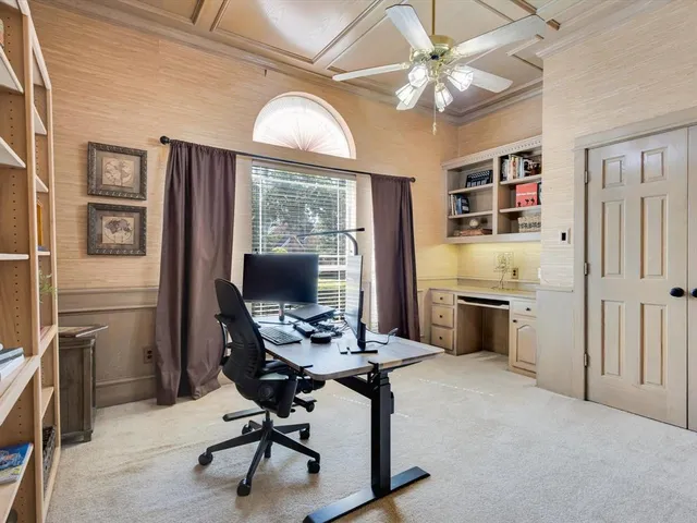 a view of a workspace with furniture and a window