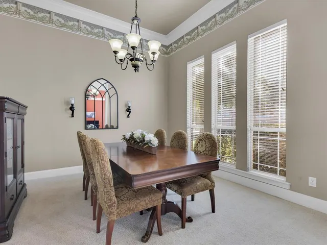 a dining room with furniture a chandelier and a window