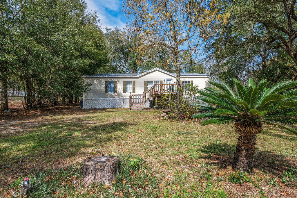 a front view of house with yard and trees around