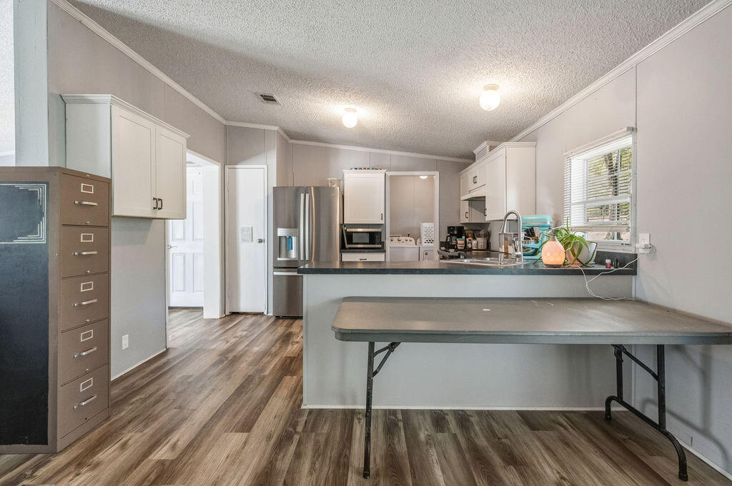 191 Beech Street Freeport, FL 32439 - Photo 4 of 18 a kitchen with stainless steel appliances a refrigerator sink and wooden cabinets