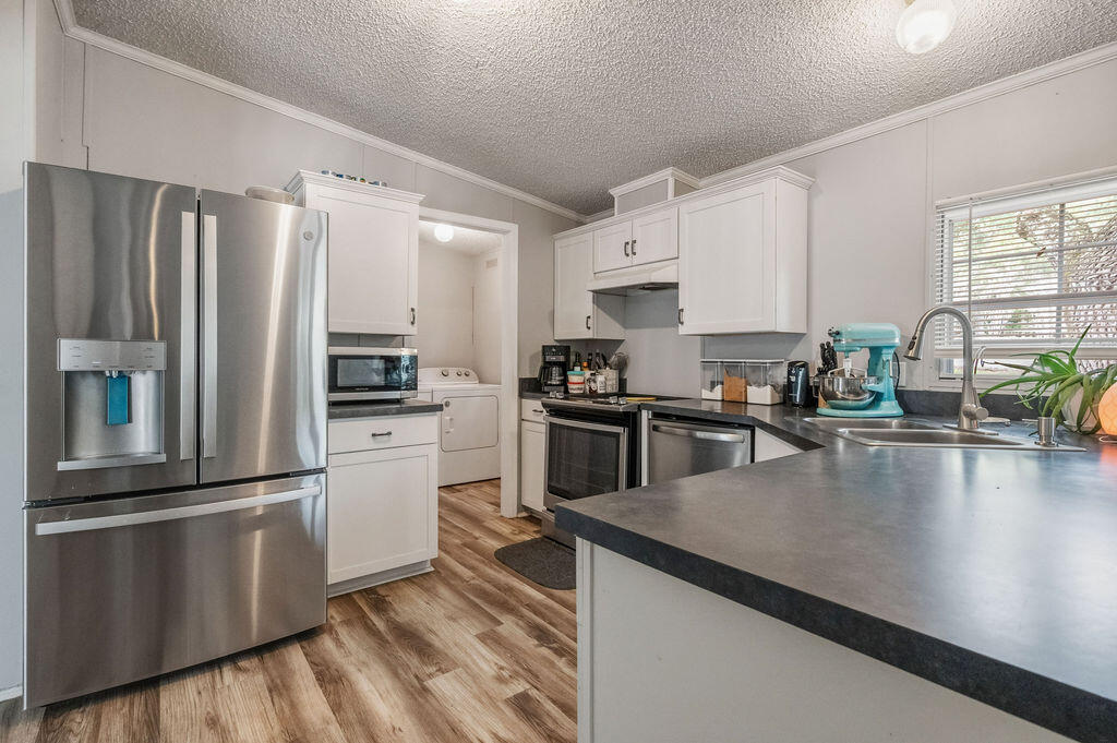 191 Beech Street Freeport, FL 32439 - Photo 6 of 18 a kitchen with granite countertop a refrigerator a sink a stove and cabinets