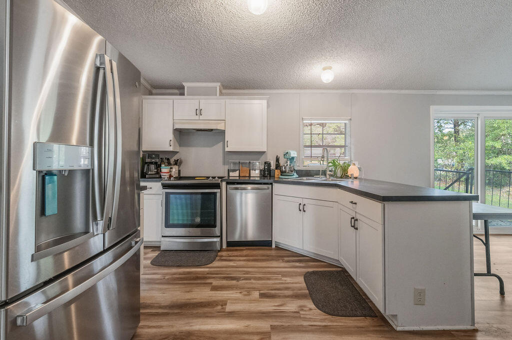 191 Beech Street Freeport, FL 32439 - Photo 7 of 18 a kitchen with granite countertop a refrigerator stove and sink
