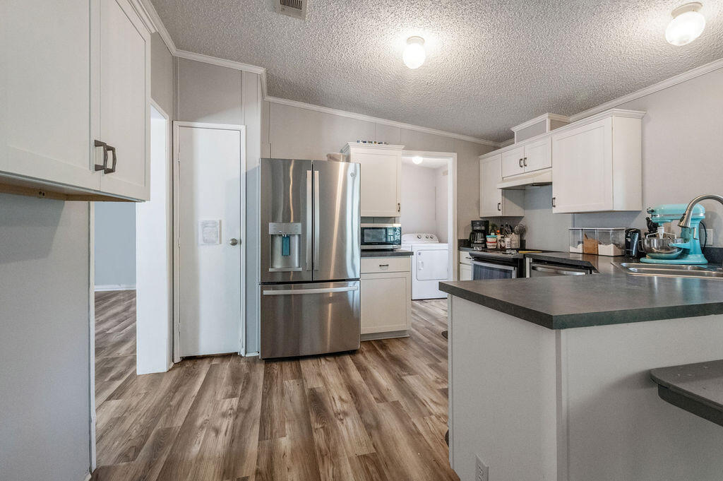191 Beech Street Freeport, FL 32439 - Photo 9 of 18 a kitchen with granite countertop a refrigerator stove and sink