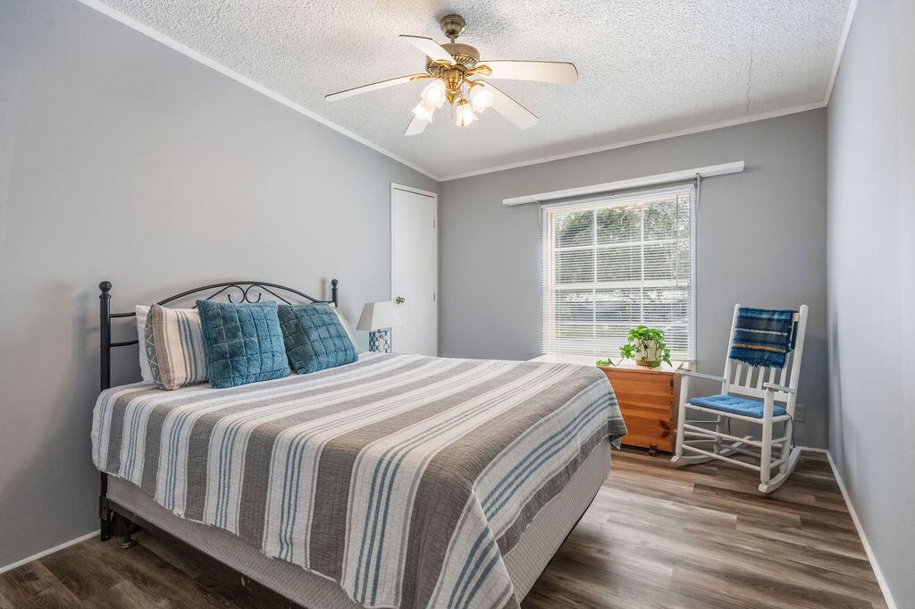191 Beech Street Freeport, FL 32439 - Photo 10 of 18 a bedroom with a bed a chandelier and a bookshelf