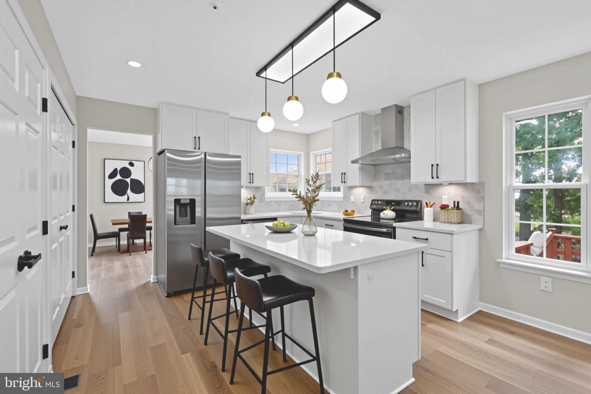 3003 Hillside Avenue Landover, MD 20785 - Photo 2 of 38 a kitchen with stainless steel appliances a table chairs refrigerator and cabinets
