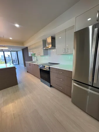 a kitchen with stainless steel appliances granite countertop a refrigerator a stove and a sink