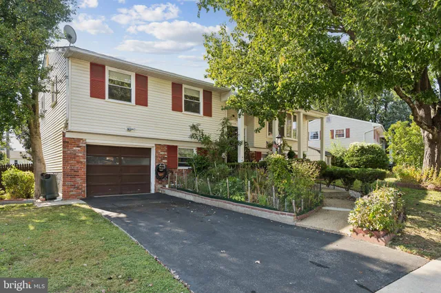 a view of a house with a yard and potted plants