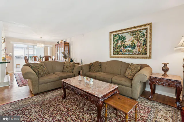 a living room with furniture a rug and a painting on the wall
