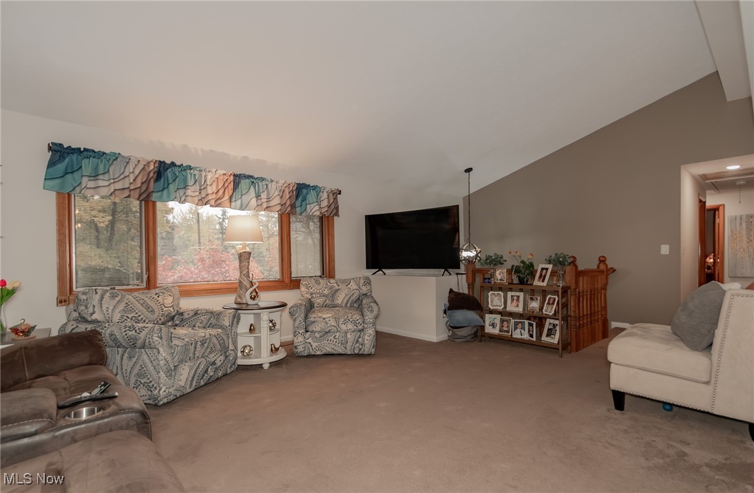 12745 Carter Road Painesville, OH 44077 - Photo 10 of 50 Carpeted living room featuring vaulted ceiling and attic access