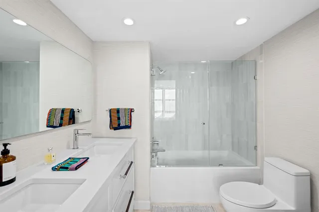 a bathroom with a tub sink and mirror
