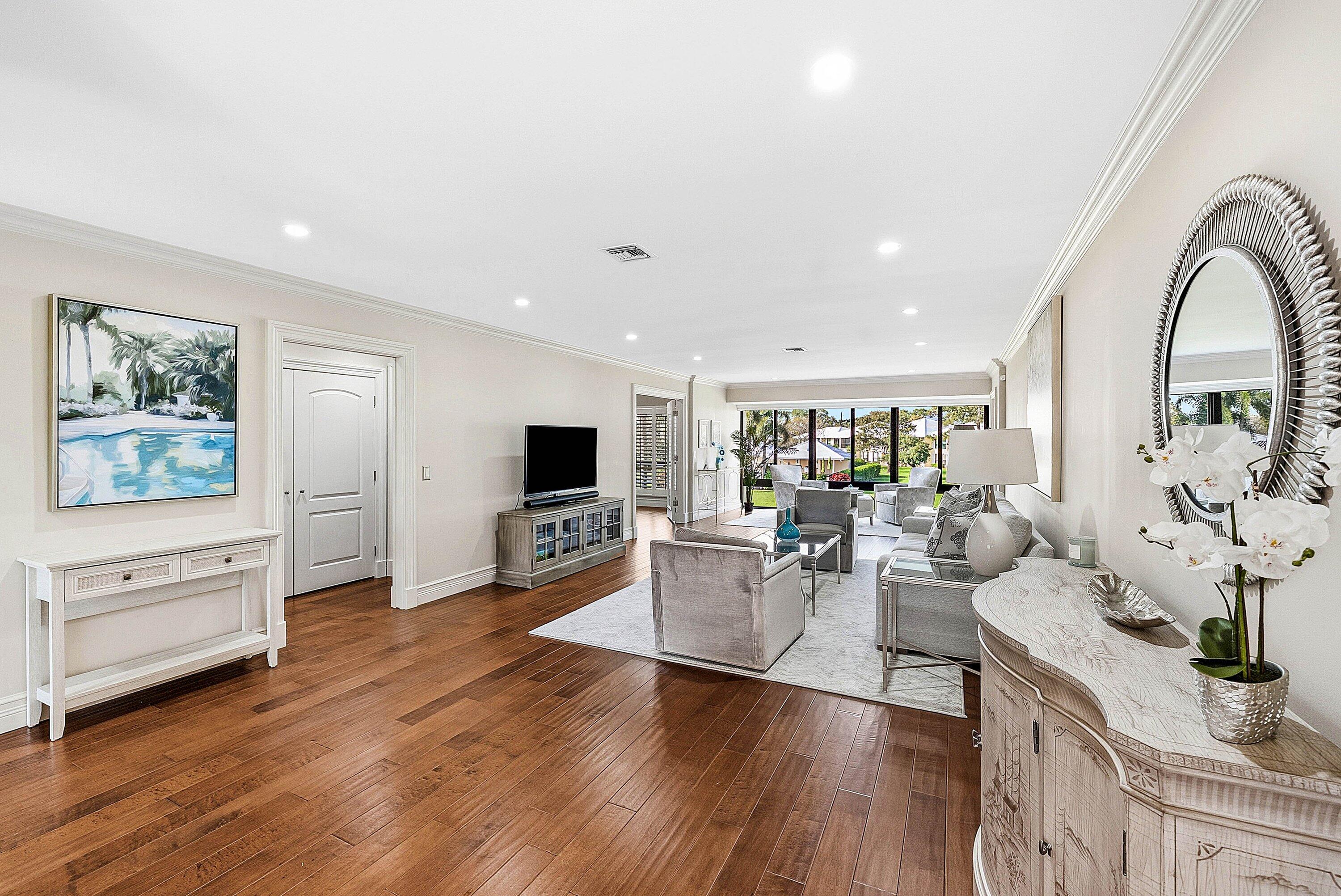 3675 Quail Ridge Drive, Unit BOBWHITE B Boynton Beach, FL 33436 - Photo 16 of 48 a living room with furniture flat screen tv and wooden floor