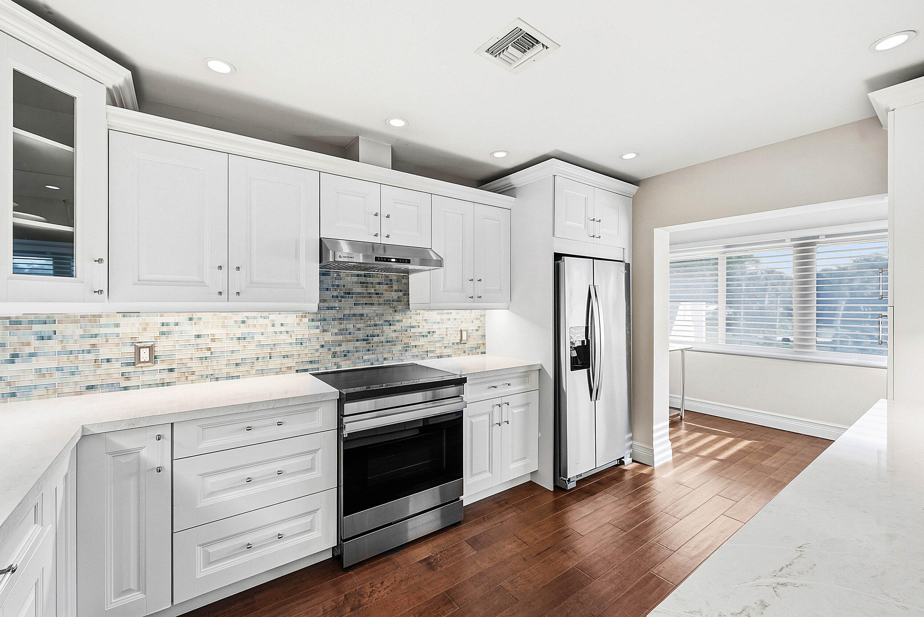 3675 Quail Ridge Drive, Unit BOBWHITE B Boynton Beach, FL 33436 - Photo 19 of 48 a kitchen with stainless steel appliances granite countertop a refrigerator and a stove top oven