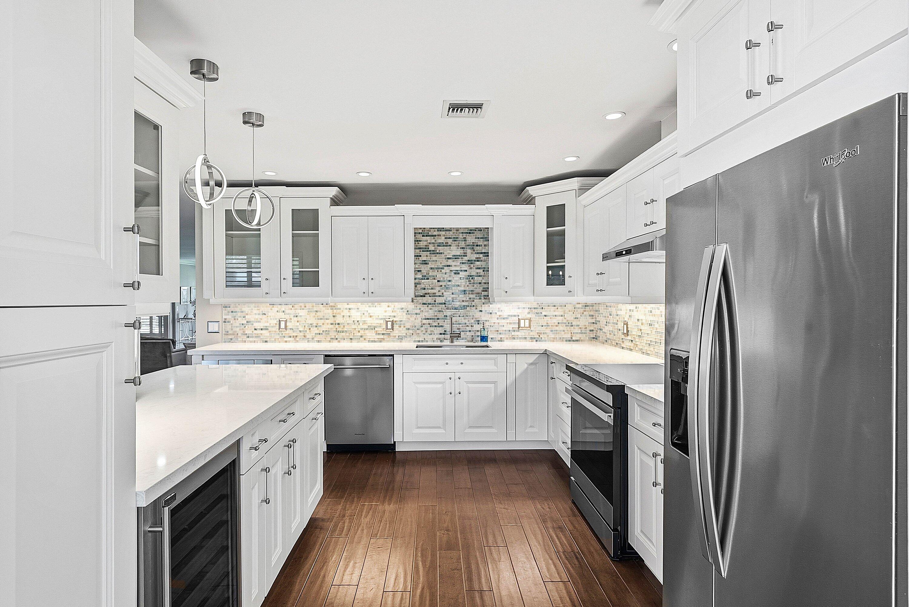 3675 Quail Ridge Drive, Unit BOBWHITE B Boynton Beach, FL 33436 - Photo 20 of 48 a kitchen with granite countertop a sink stove refrigerator and cabinets