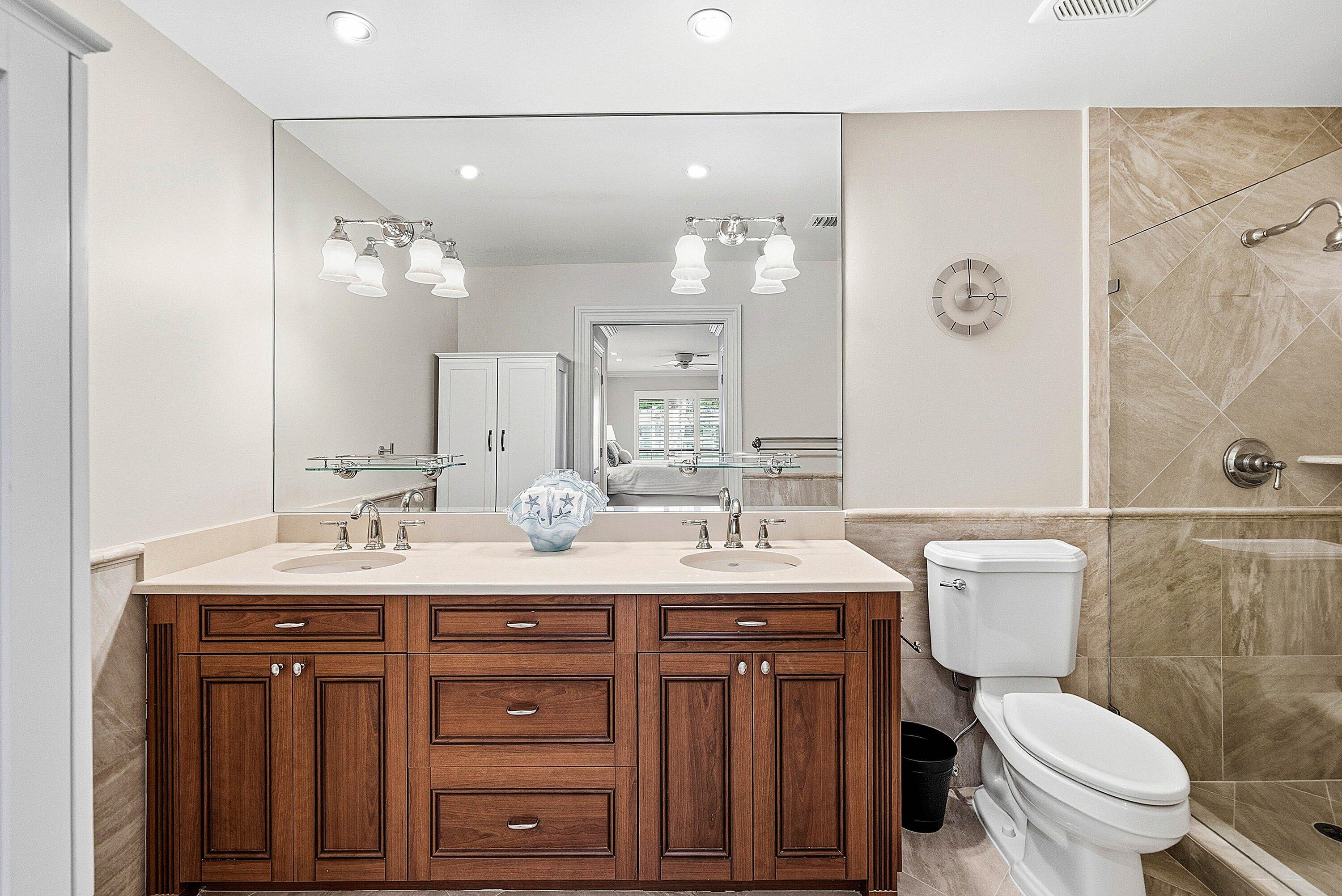 3675 Quail Ridge Drive, Unit BOBWHITE B Boynton Beach, FL 33436 - Photo 26 of 48 a bathroom with a granite countertop toilet sink and mirror