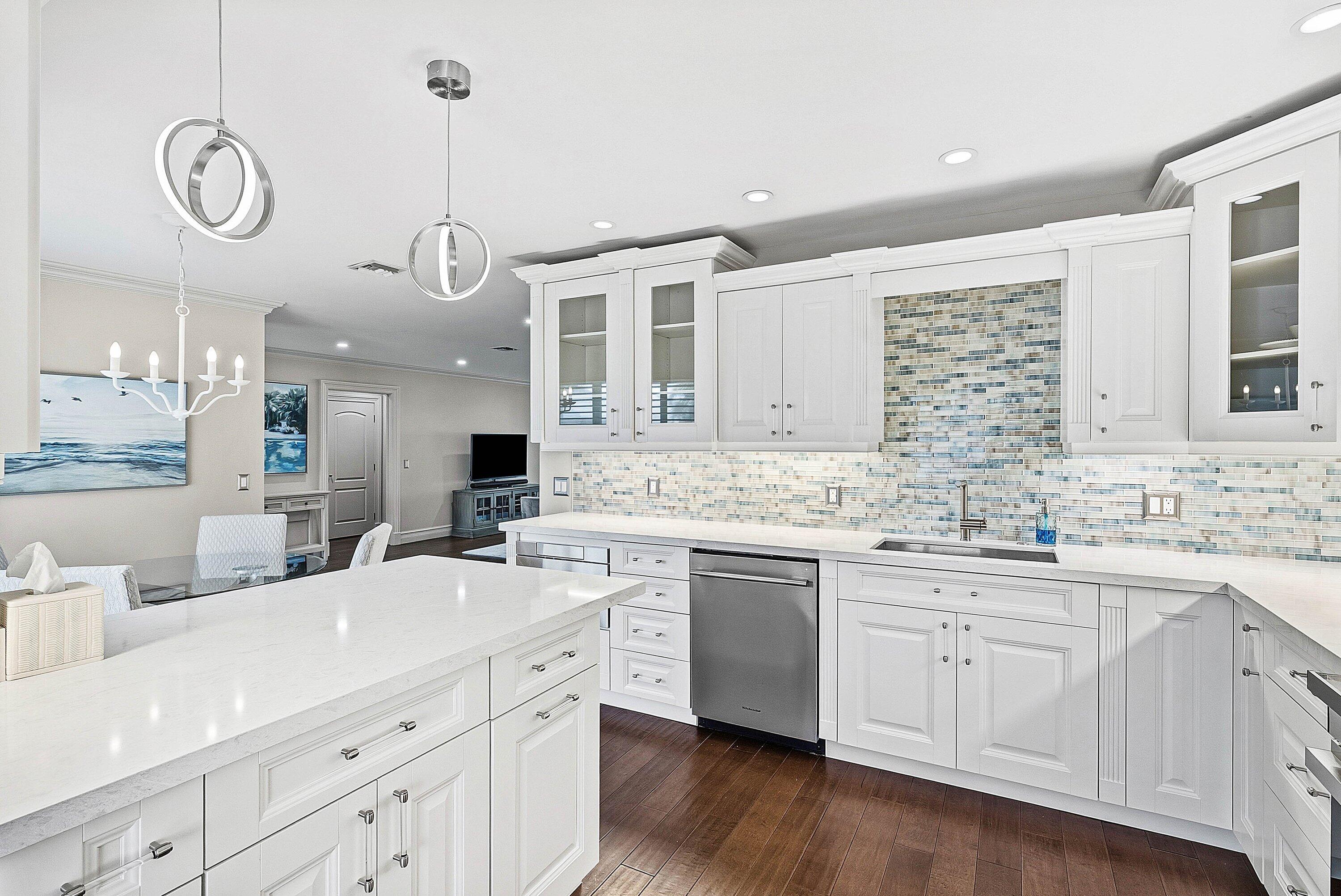 3675 Quail Ridge Drive, Unit BOBWHITE B Boynton Beach, FL 33436 - Photo 3 of 48 a kitchen with a sink dishwasher a stove a dining table and chairs