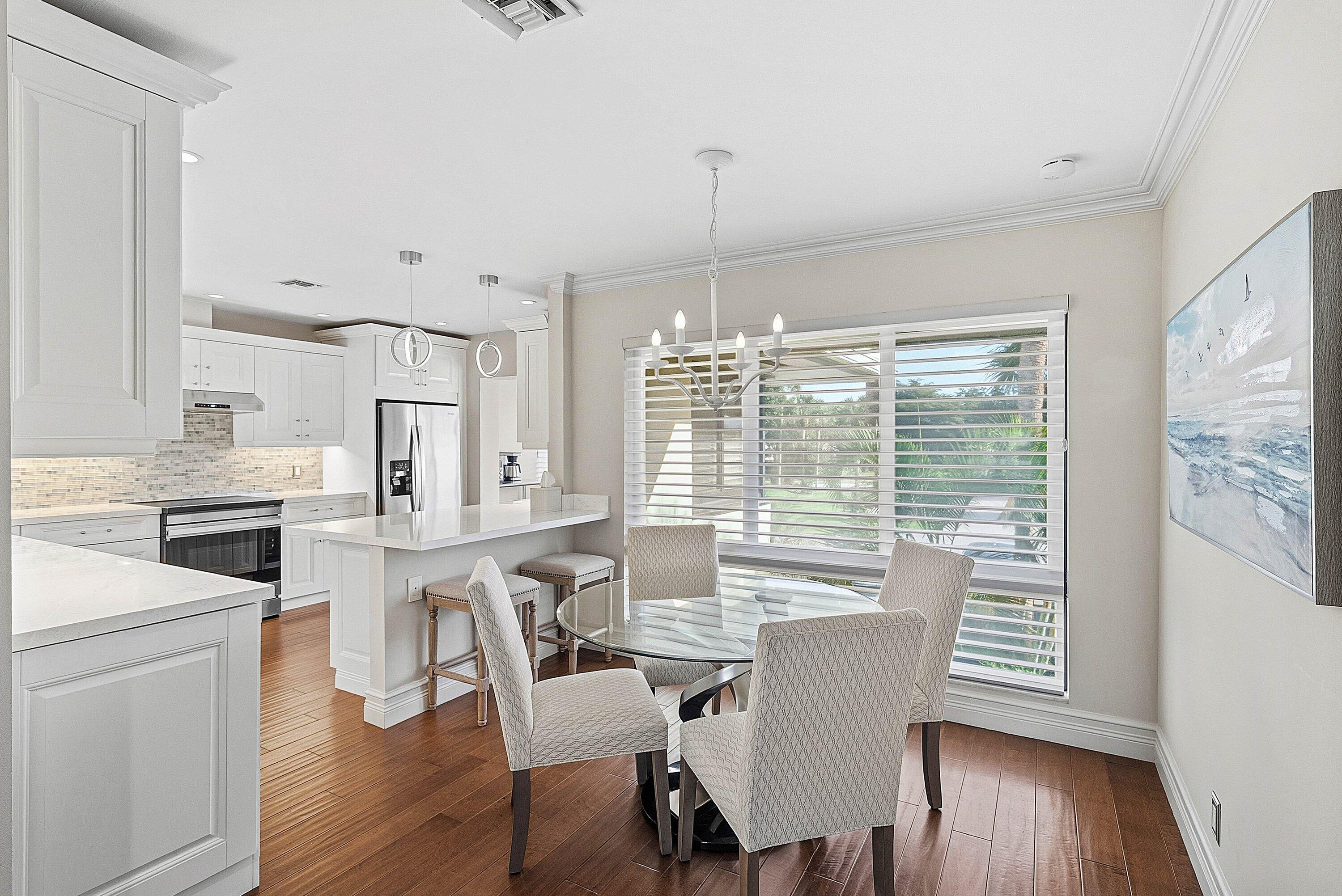 3675 Quail Ridge Drive, Unit BOBWHITE B Boynton Beach, FL 33436 - Photo 5 of 48 a view of a dining room with furniture window and wooden floor