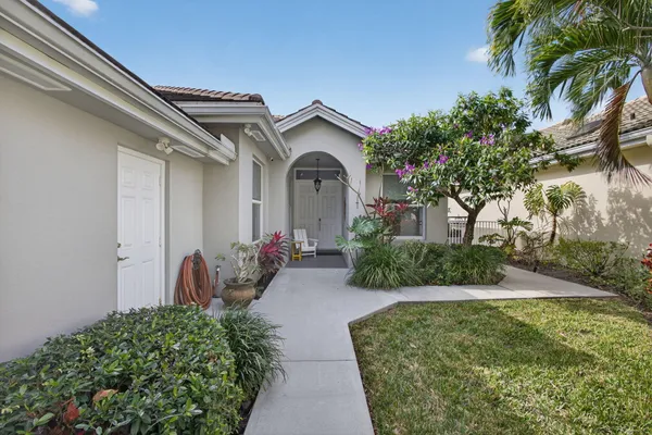 a view of a house with a small yard plants and palm trees