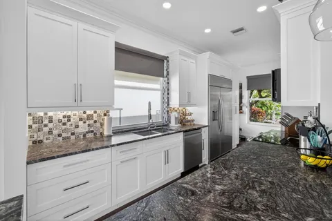 a kitchen with sink stove and cabinets