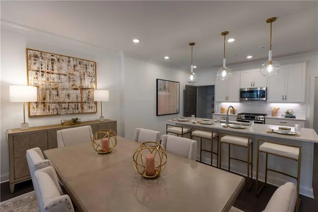 a kitchen with kitchen island a stove a table and chairs in it