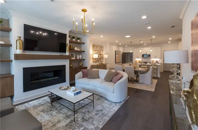 a living room with furniture fireplace and kitchen view