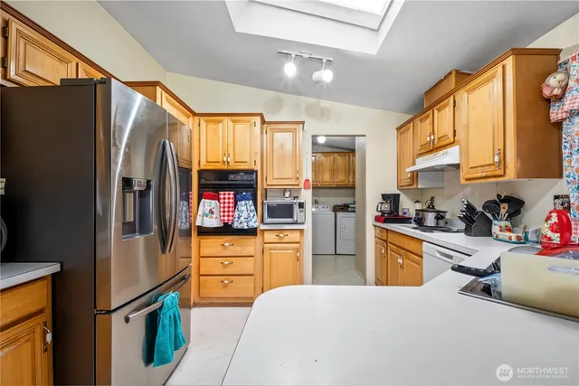 a kitchen with stainless steel appliances granite countertop a refrigerator and a stove top oven