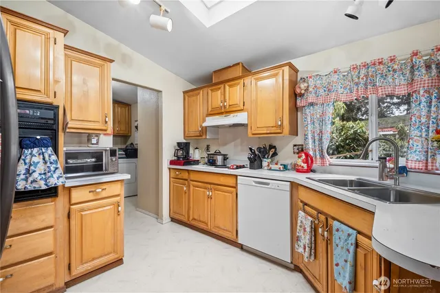 a kitchen with stainless steel appliances a sink window and cabinets