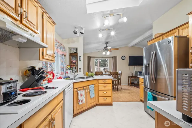a kitchen that has a lot of cabinets a sink and appliances