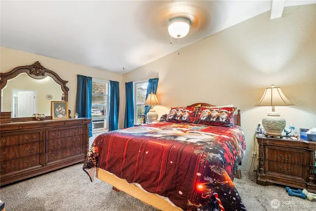 a bedroom with a bed and dresser with mirror