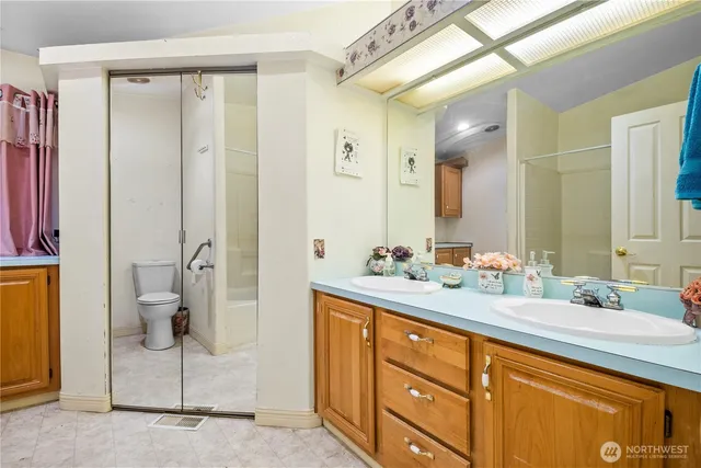 a bathroom with a double vanity sink mirror and shower