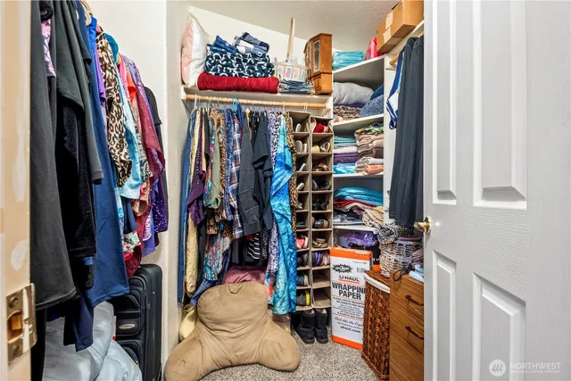 a view of walk in closet with clothes