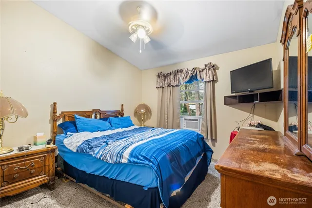 a bedroom with bed and flat tv screen