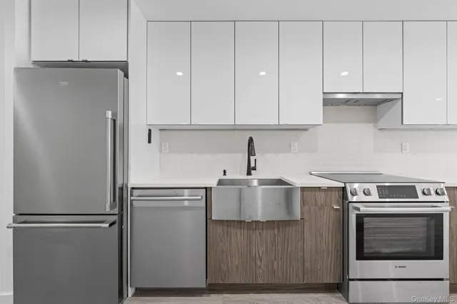a kitchen with stainless steel appliances white cabinets and a refrigerator