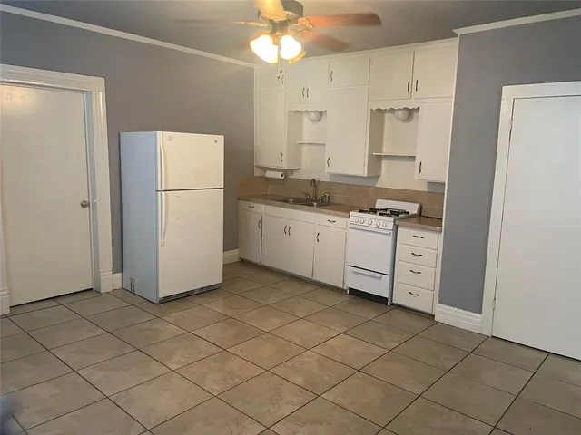a kitchen with a sink a refrigerator and cabinets