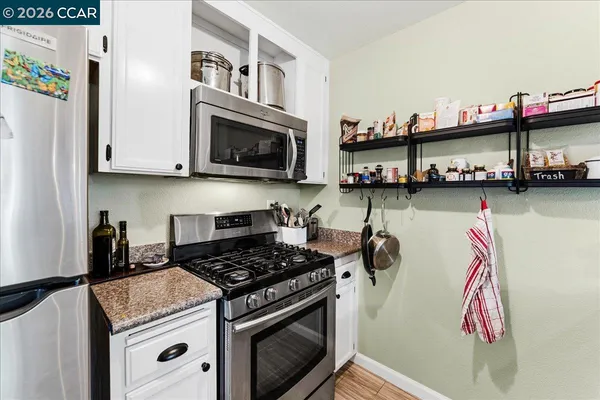 a kitchen with stainless steel appliances granite countertop a stove and a microwave