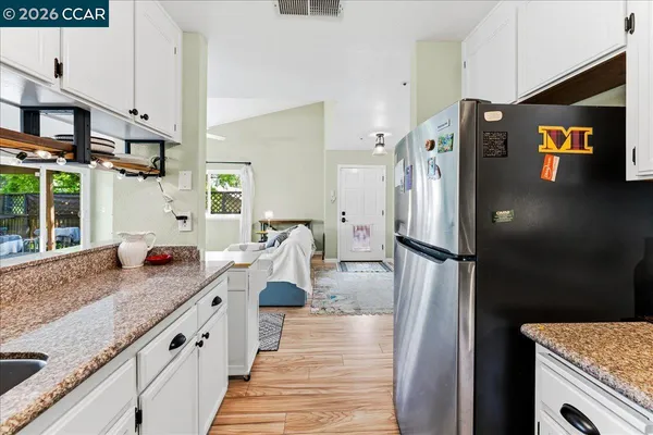 a kitchen with stainless steel appliances granite countertop a refrigerator a stove and a sink