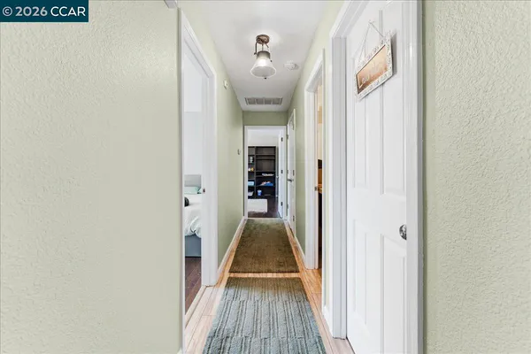 a view of a hallway with wooden floor and staircase
