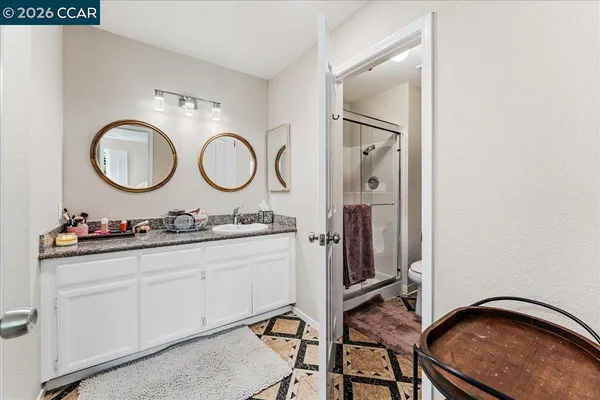 a bathroom with a granite countertop sink and a mirror